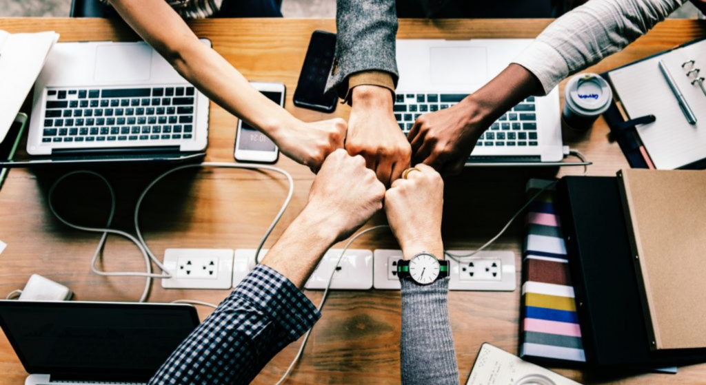 Team high fiving on a desk